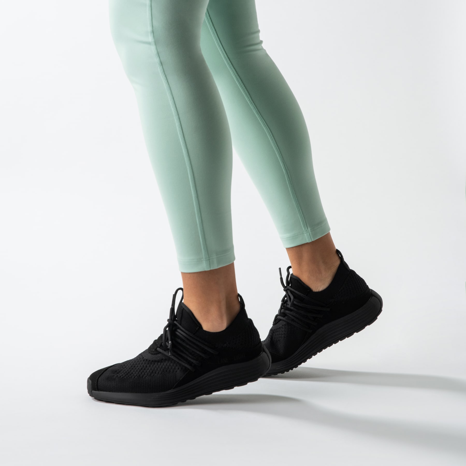 LANEEIGHT-TRAINER-AD-1-CarbonBlack-WomensOnFoot-min