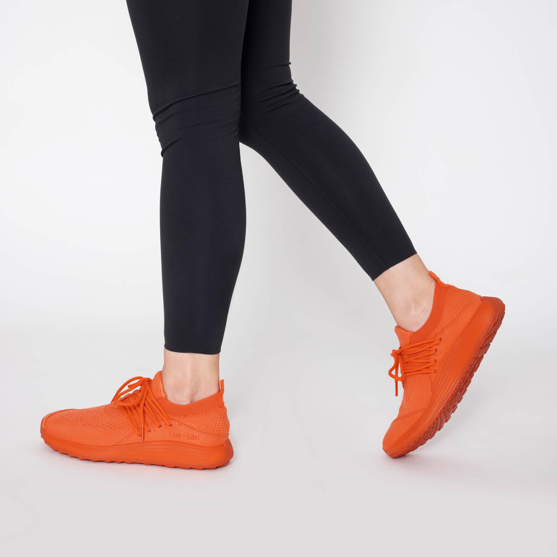 LANEEIGHT-TRAINER-AD-1-SunriseOrange-WomensOnFoot